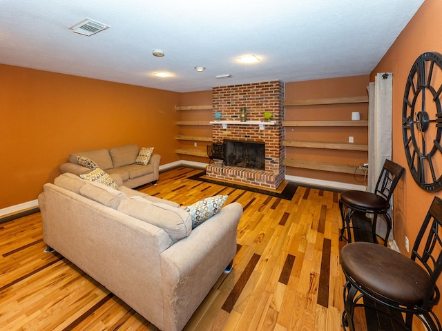 living room featuring a fireplace and light wood-type flooring