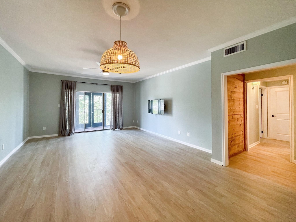 spare room with ceiling fan, ornamental molding, and light hardwood / wood-style floors