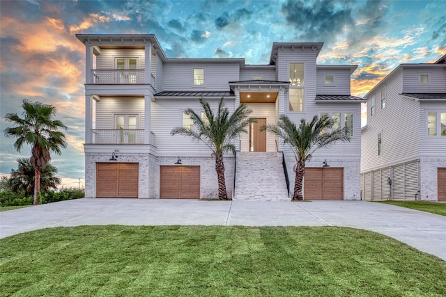 view of front facade with a yard, a balcony, and a garage