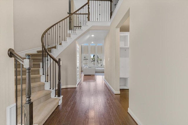 entryway with a towering ceiling and dark hardwood / wood-style floors