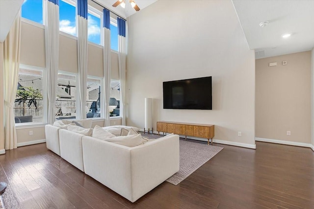 living room with ceiling fan and dark wood-type flooring