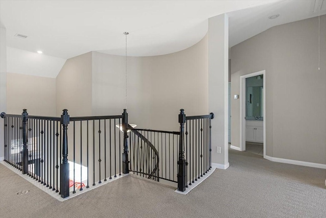 hall featuring vaulted ceiling and carpet