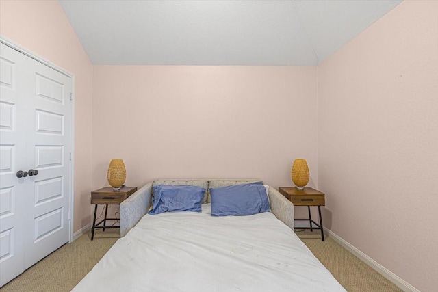 bedroom with lofted ceiling and light colored carpet