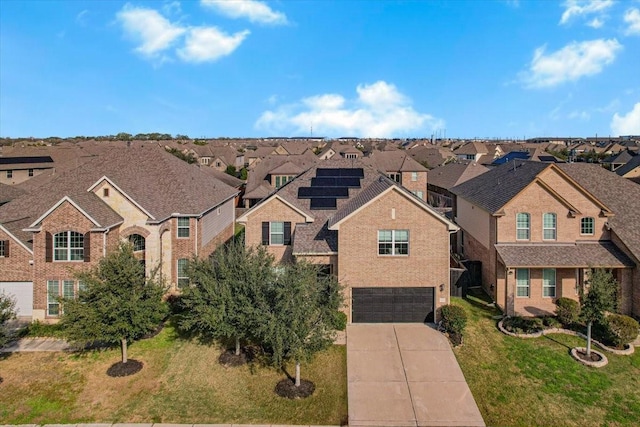 view of front of house featuring a garage, solar panels, and a front yard