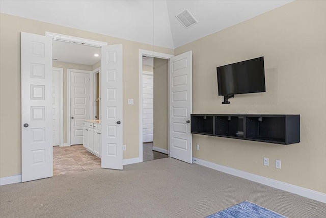 unfurnished bedroom featuring vaulted ceiling and light carpet