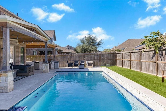 view of pool featuring an outdoor kitchen and a patio area