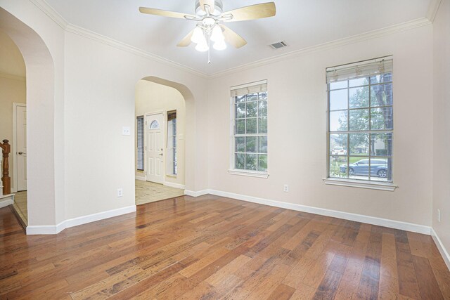 empty room with hardwood / wood-style flooring, ceiling fan, and crown molding