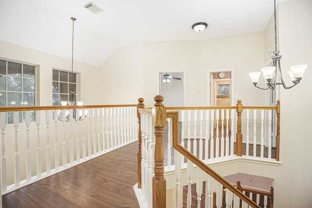 corridor featuring lofted ceiling, a notable chandelier, and dark wood-type flooring