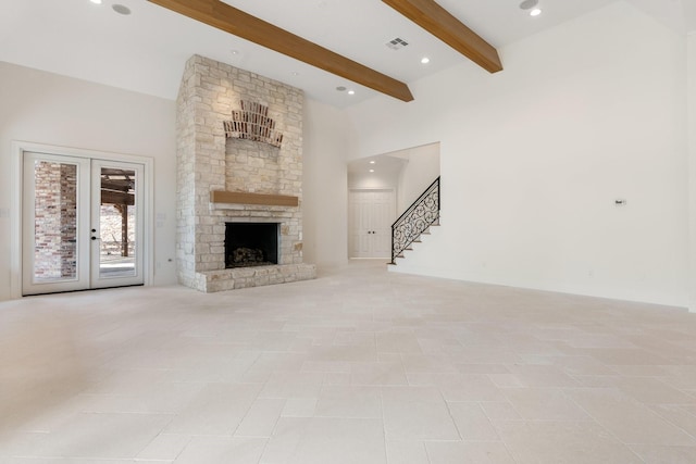 unfurnished living room featuring french doors, high vaulted ceiling, a fireplace, and beamed ceiling