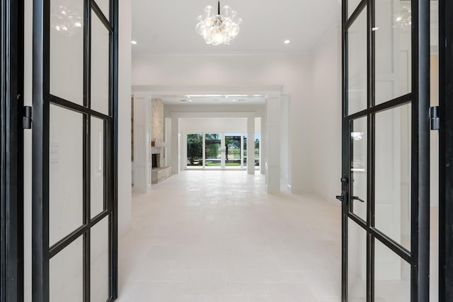 corridor featuring crown molding and a chandelier