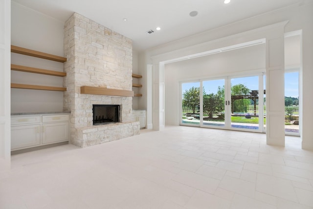 unfurnished living room featuring a fireplace, ornamental molding, and built in features