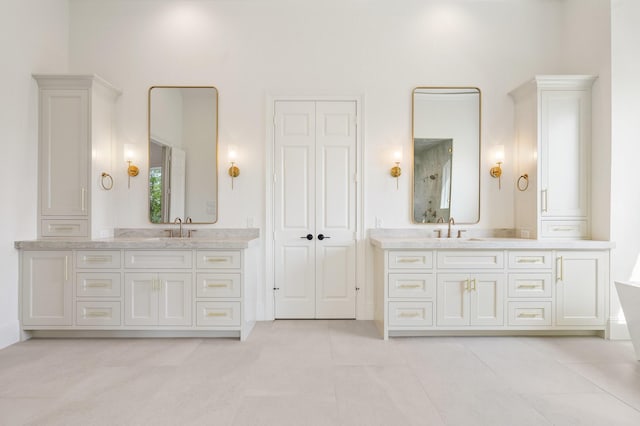 bathroom featuring a towering ceiling, vanity, and tile patterned floors