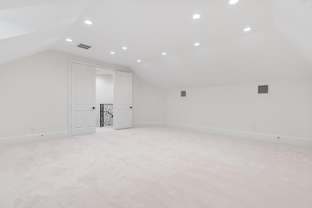 additional living space featuring lofted ceiling and light colored carpet