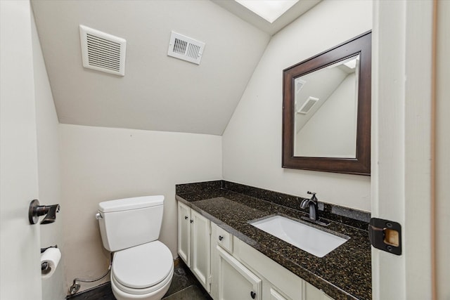 bathroom with lofted ceiling, vanity, and toilet