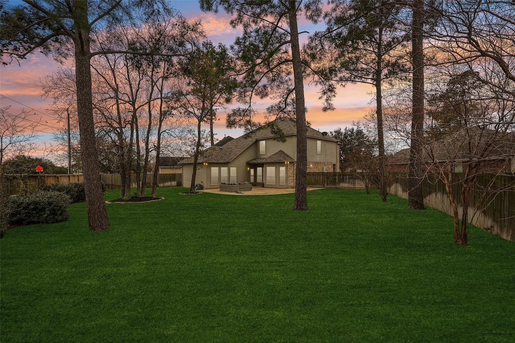 yard at dusk featuring a patio