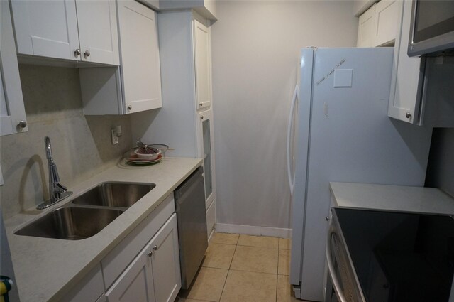 kitchen with white cabinets, appliances with stainless steel finishes, light tile patterned floors, and sink