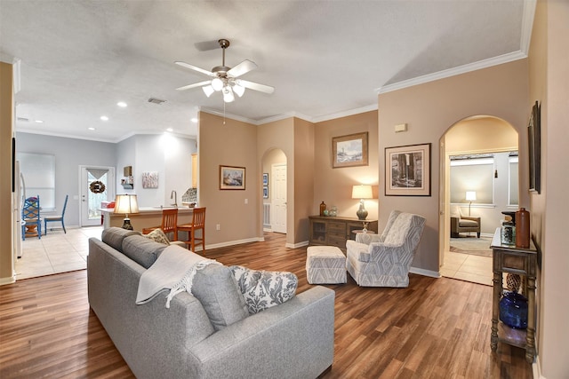 living room featuring ceiling fan, crown molding, and hardwood / wood-style flooring