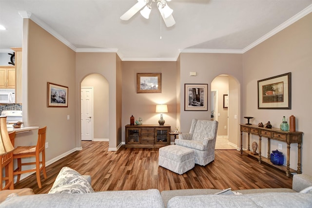 living room featuring hardwood / wood-style floors, ornamental molding, and ceiling fan