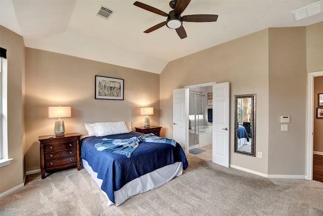 bedroom featuring ceiling fan, light carpet, ensuite bath, and lofted ceiling