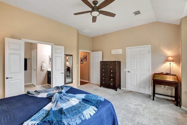 bedroom with ceiling fan, light carpet, lofted ceiling, and ensuite bathroom