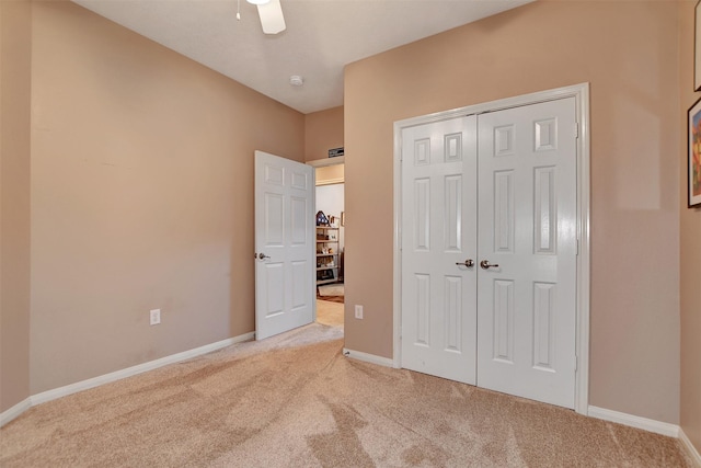 unfurnished bedroom with a closet, ceiling fan, and light colored carpet