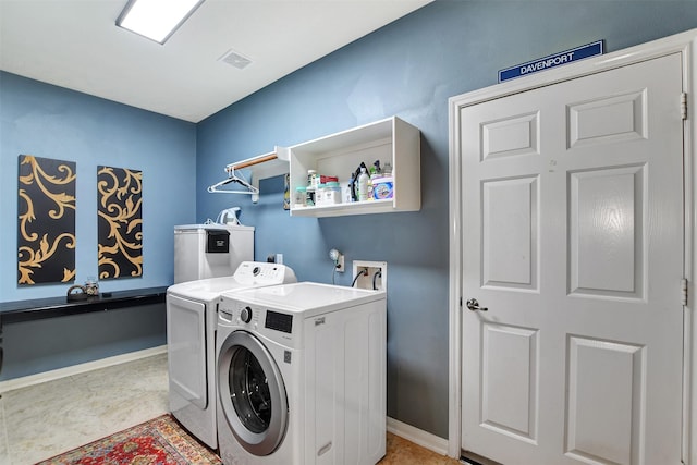 laundry area with water heater and washing machine and clothes dryer