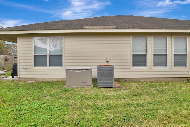 view of side of home featuring central AC unit and a lawn