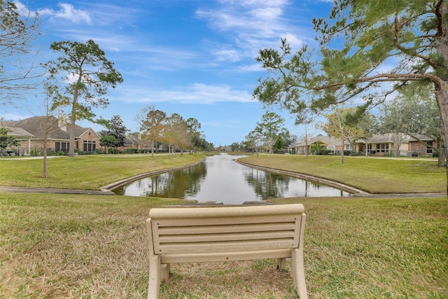 surrounding community featuring a water view and a lawn