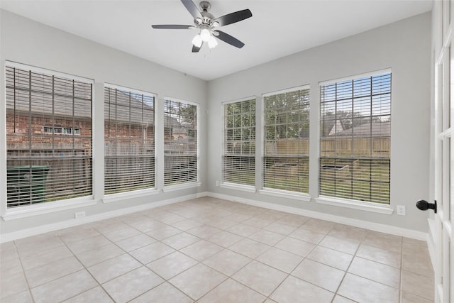 unfurnished sunroom featuring ceiling fan