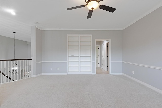 carpeted empty room with ceiling fan and crown molding