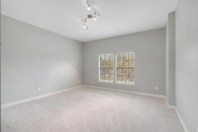 carpeted empty room with track lighting