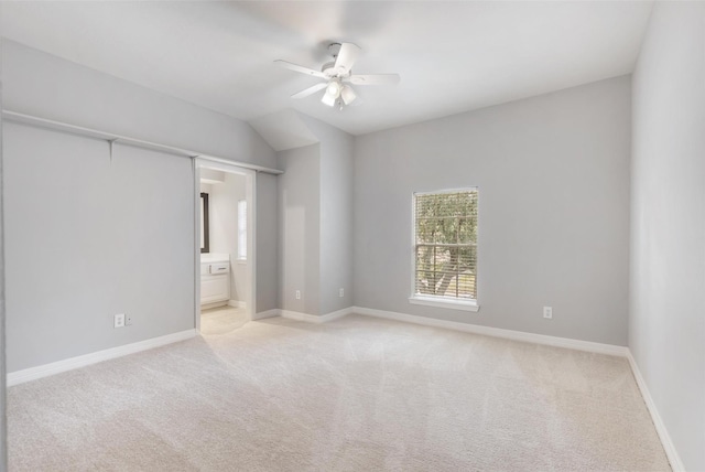 unfurnished bedroom with ceiling fan, ensuite bathroom, and light carpet