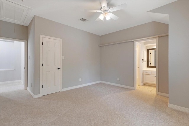 unfurnished bedroom with connected bathroom, light carpet, and ceiling fan