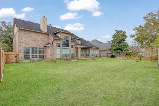 back of house with a lawn