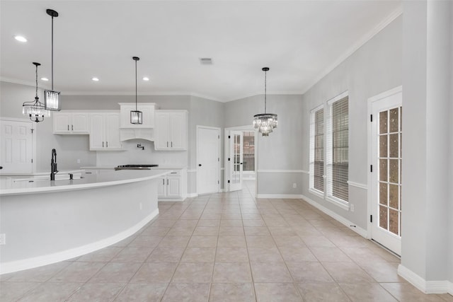 kitchen featuring crown molding, pendant lighting, sink, white cabinetry, and light tile patterned flooring