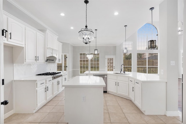 kitchen featuring sink, decorative light fixtures, white cabinets, kitchen peninsula, and appliances with stainless steel finishes