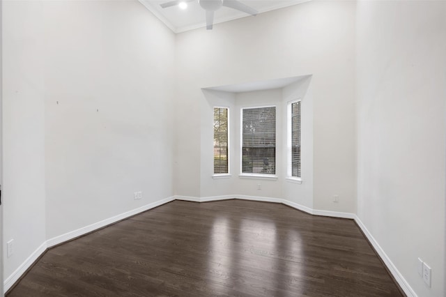 spare room with ceiling fan, crown molding, and dark wood-type flooring