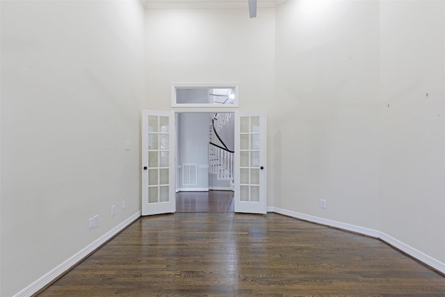 unfurnished room with french doors, a high ceiling, and dark hardwood / wood-style floors