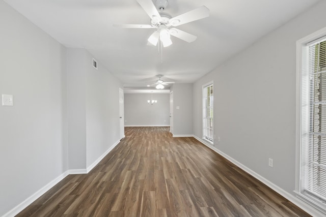 unfurnished living room with dark wood-type flooring and ceiling fan with notable chandelier