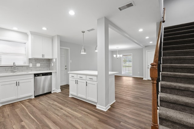 kitchen with sink, white cabinets, dishwasher, and hanging light fixtures