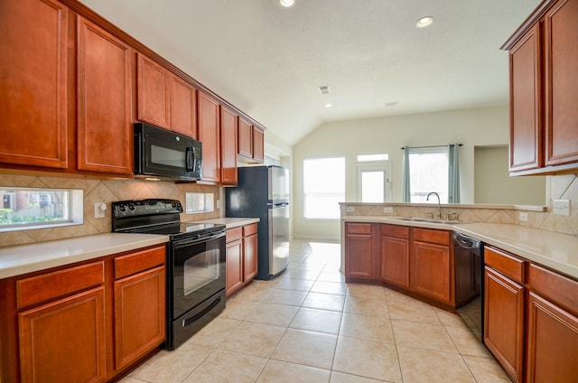 kitchen featuring tasteful backsplash, light tile patterned flooring, vaulted ceiling, black appliances, and sink