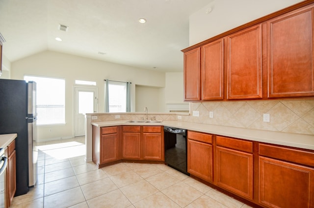 kitchen with dishwasher, tasteful backsplash, sink, stainless steel fridge, and vaulted ceiling