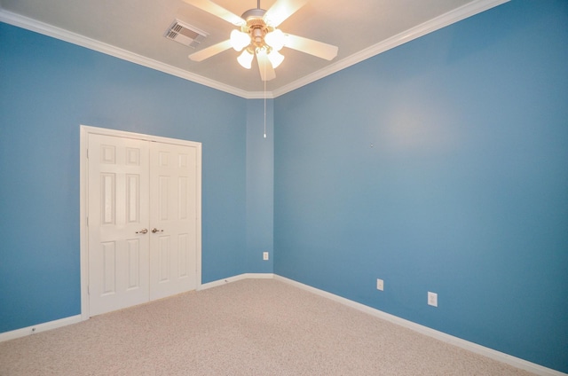 carpeted empty room featuring ceiling fan and crown molding