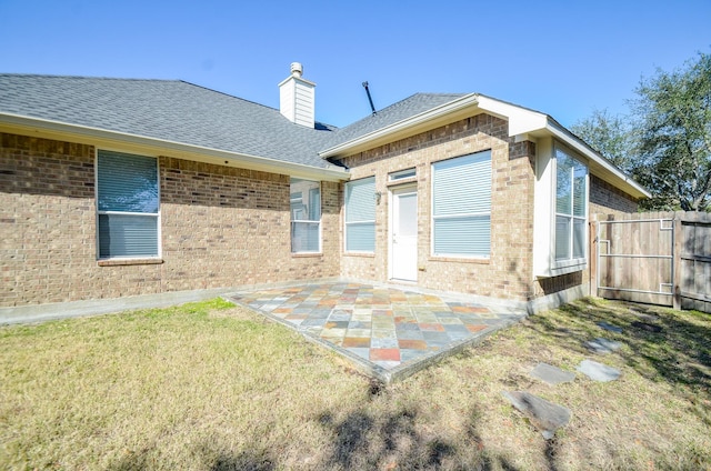 rear view of property with a patio area and a lawn