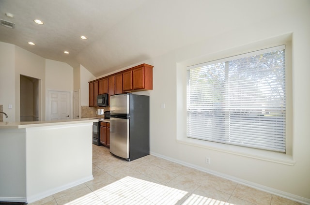 kitchen featuring tasteful backsplash, vaulted ceiling, black appliances, kitchen peninsula, and light tile patterned floors