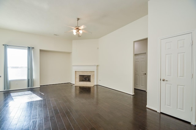 unfurnished living room featuring ceiling fan, a fireplace, and dark hardwood / wood-style floors