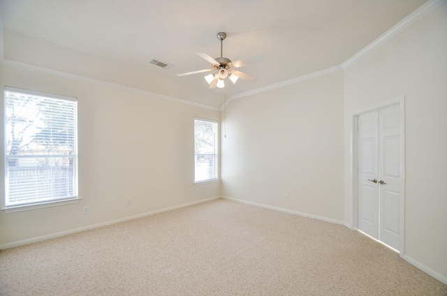 carpeted spare room featuring ceiling fan and ornamental molding