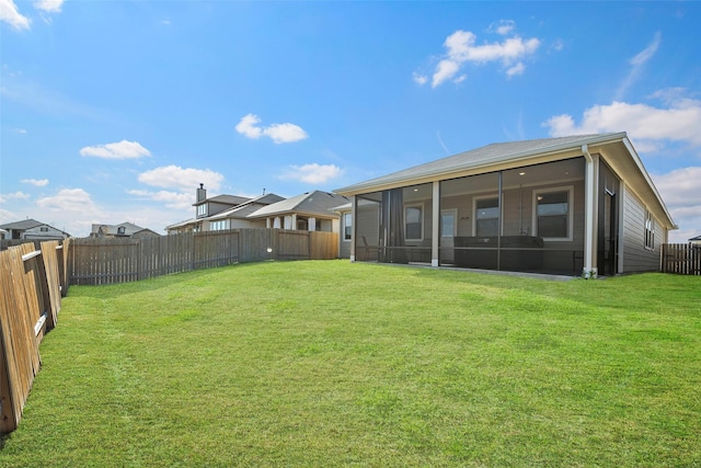 back of house featuring a sunroom and a lawn