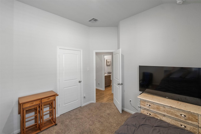 bedroom with lofted ceiling and light colored carpet