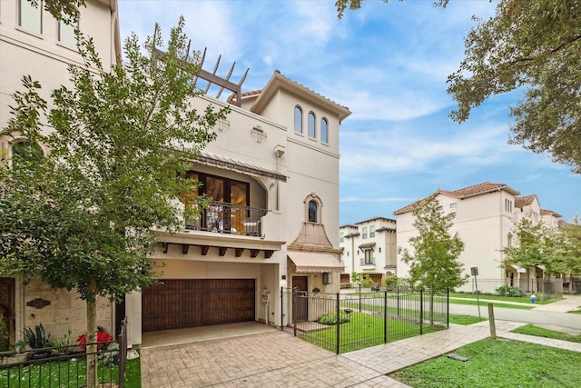 mediterranean / spanish-style home with a balcony, a front yard, and a garage